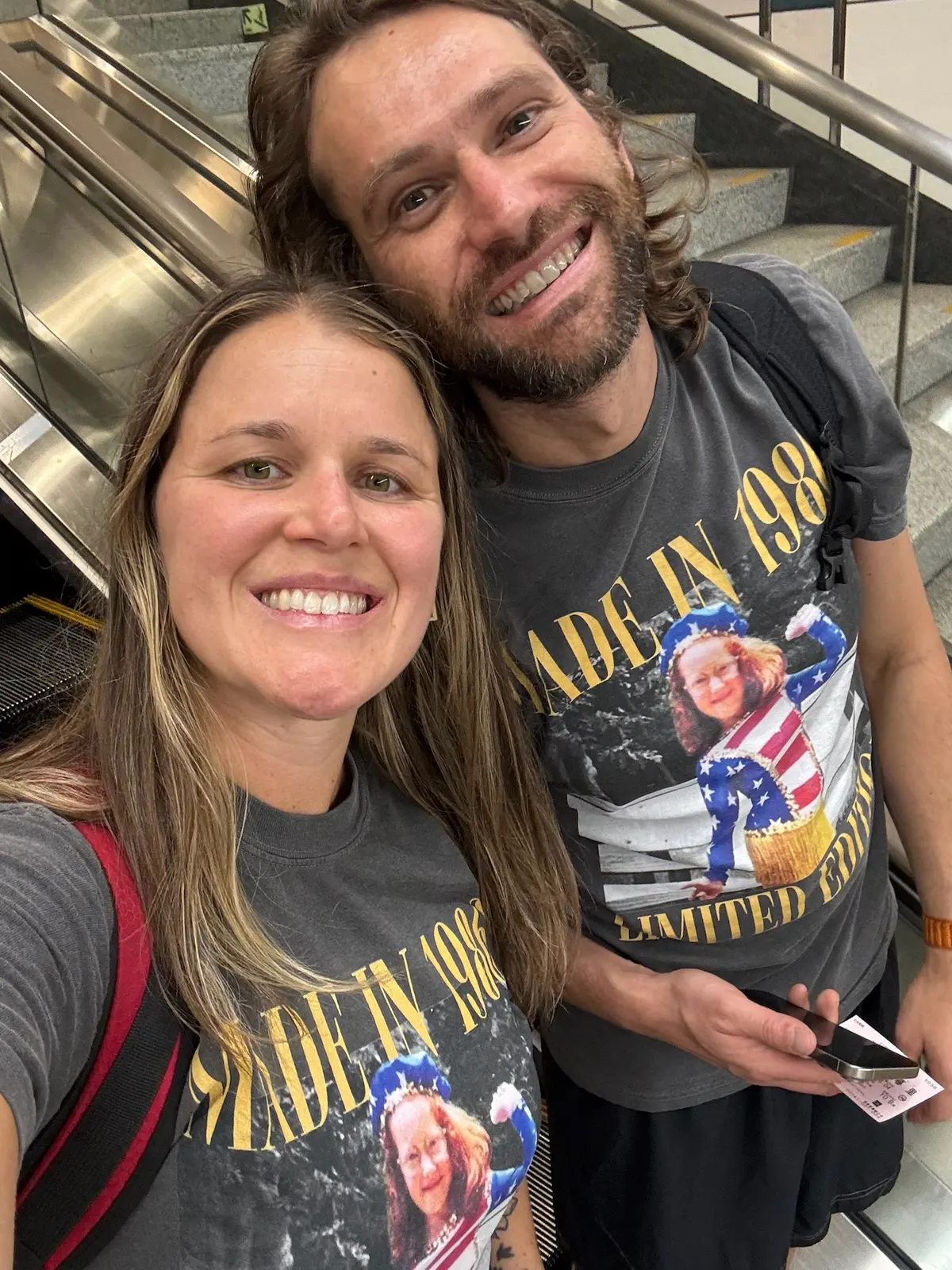 Zach and Caitlin taking a selfie on an airport escalator after arriving in Japan.