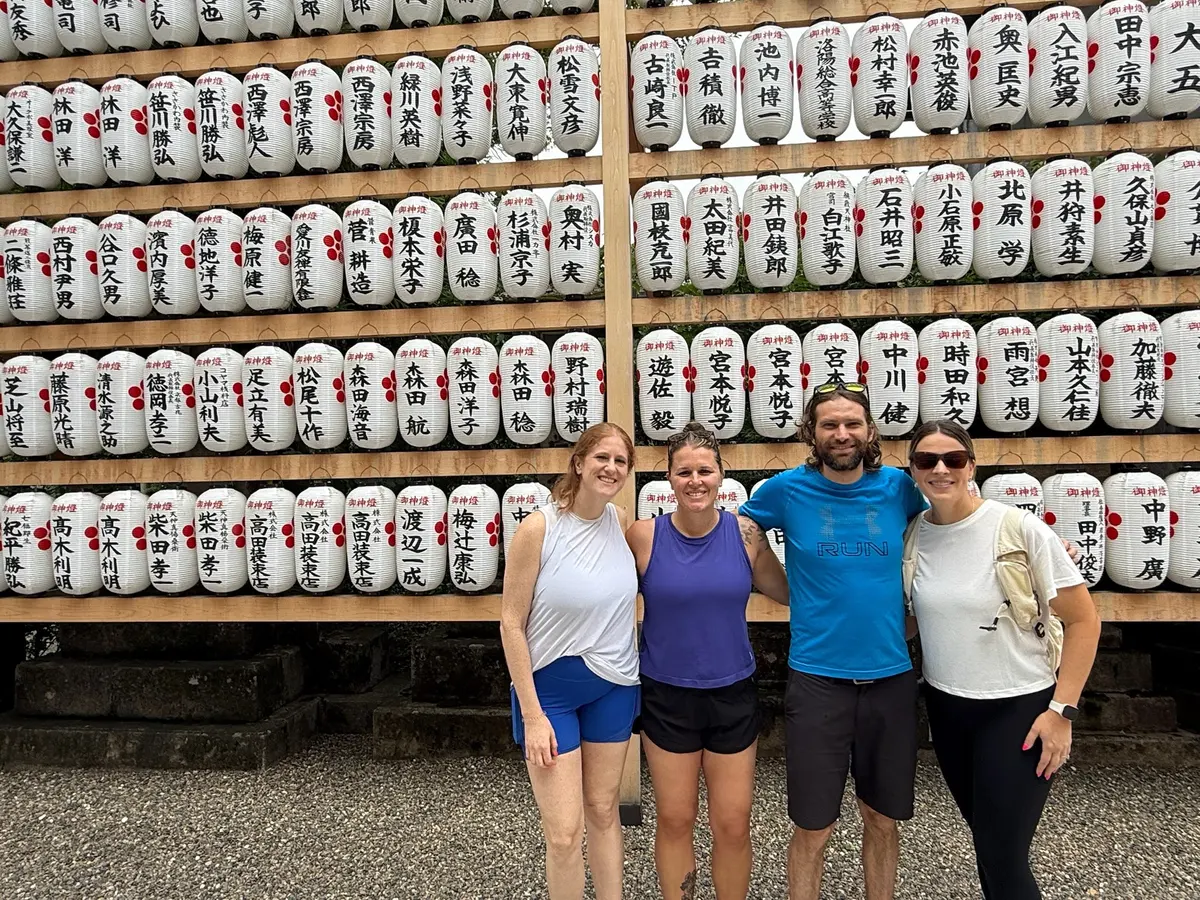 Group photo in front of decorative barrels during the Kyoto tour.