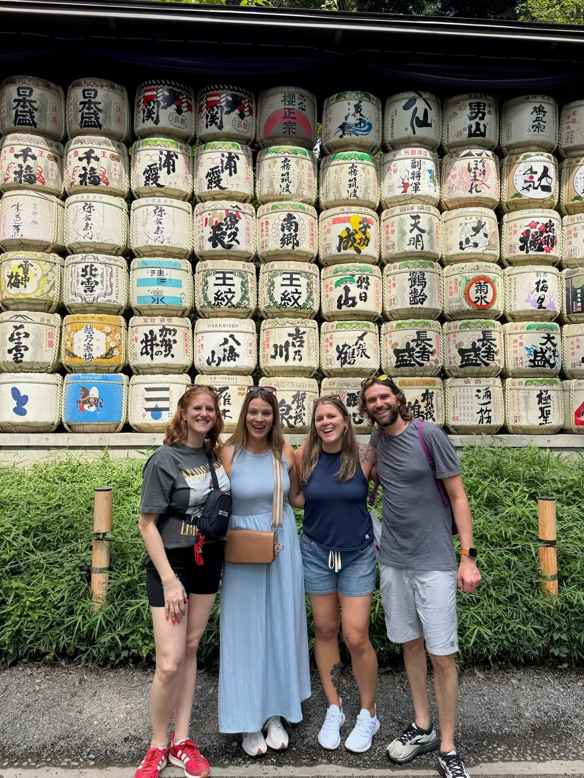 Group photo in front of decorative sake barrels in Tokyo.