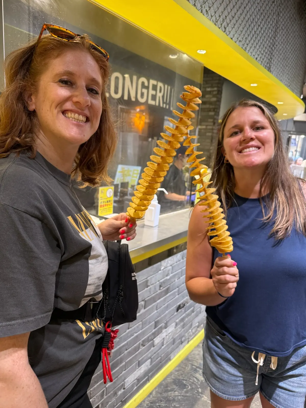 Sarah and Caitlin holding spiral fried potato snacks.