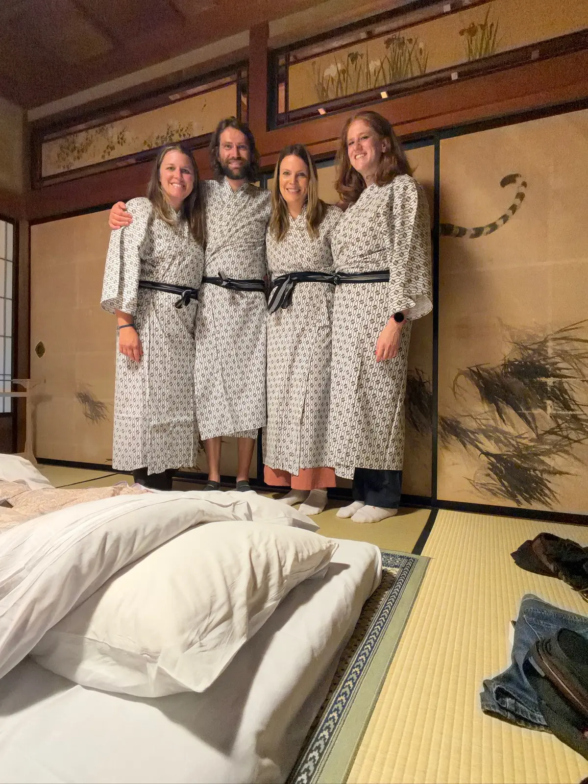 The group standing in robes inside the ryokan room.