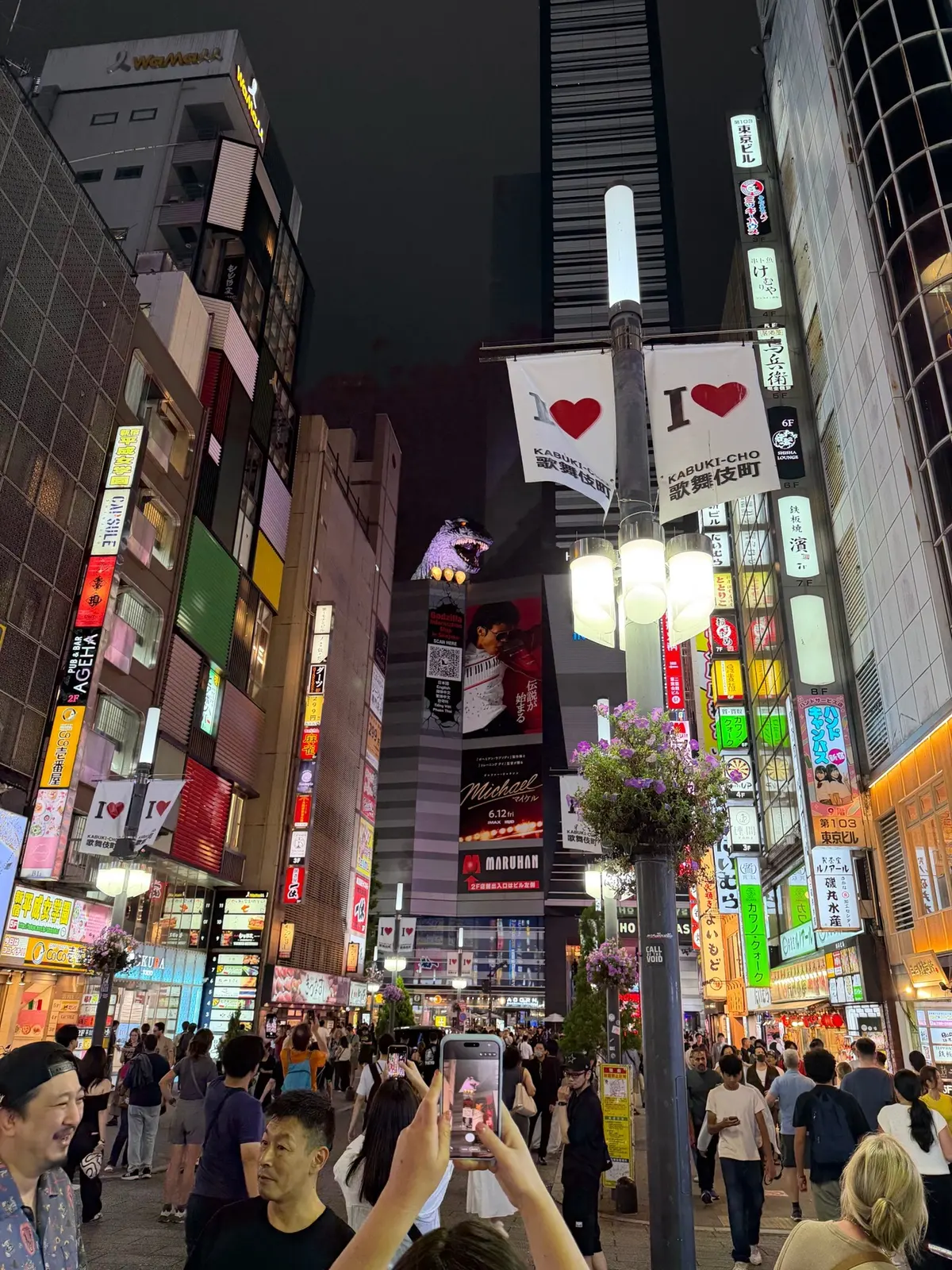 Tall buildings and bright signs in Shinjuku at night.