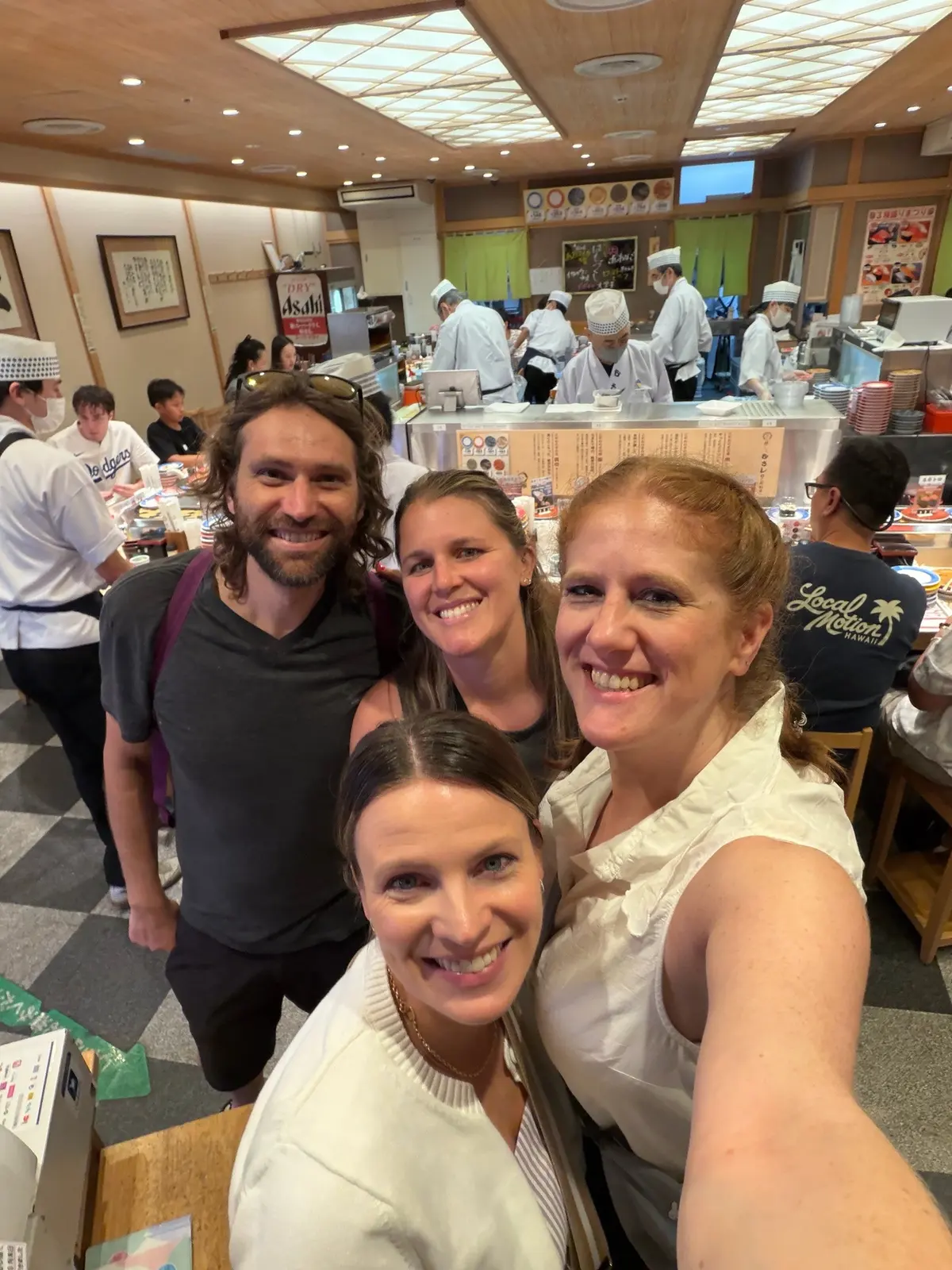 The group taking a selfie at Sushi no Musashi's conveyor-belt sushi counter.