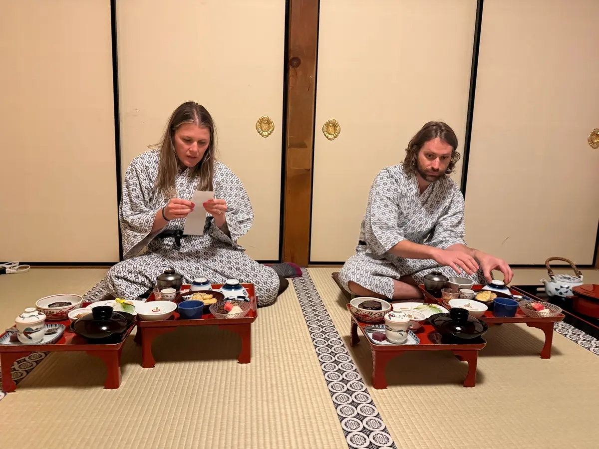 Zach and Caitlin sitting at the temple dinner table in robes.