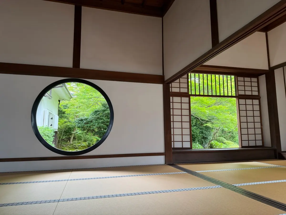 Round window looking out onto a green garden in Kyoto.